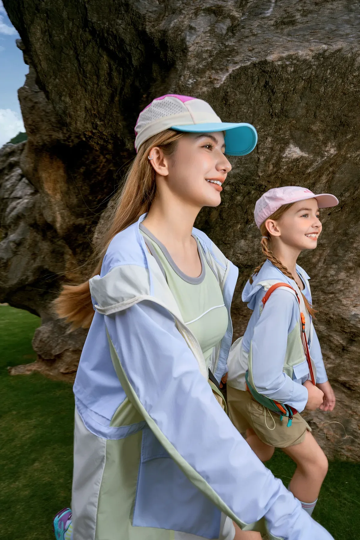 An adult and young explorer walking together through a rocky landscape
