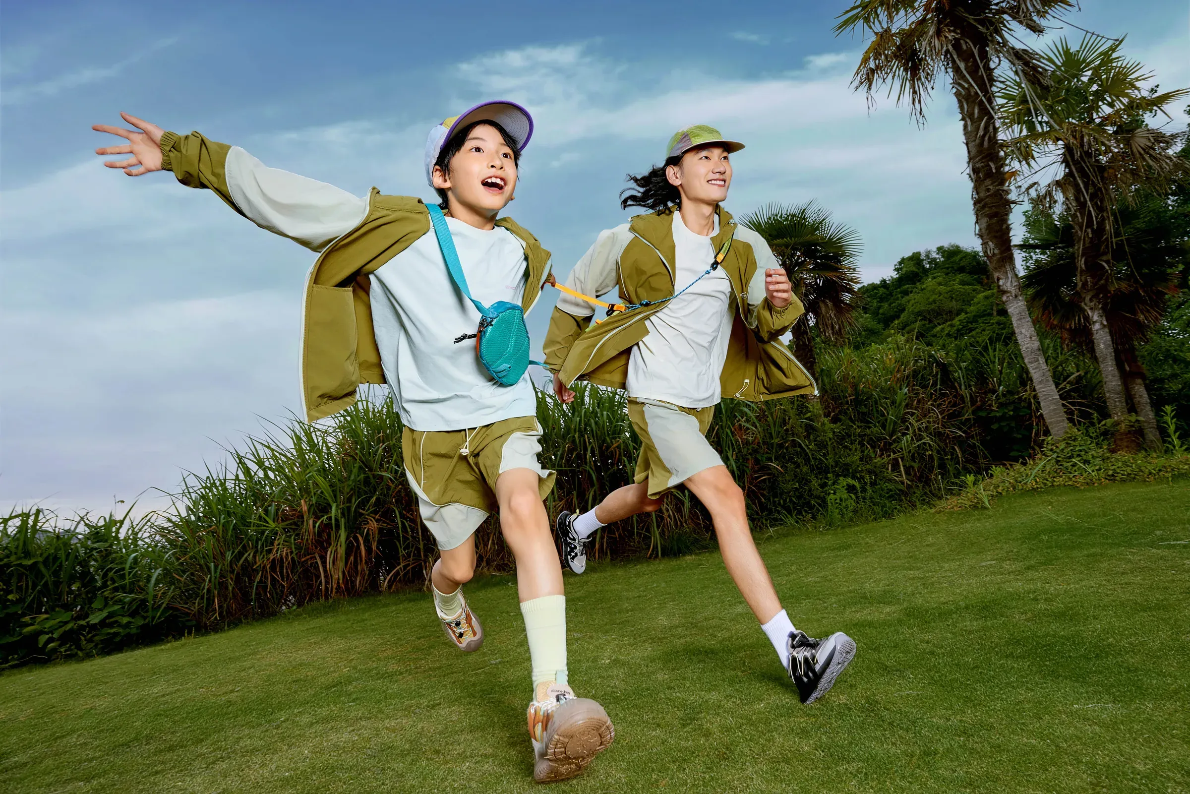 An adult and child running together in coordinated trail layers
