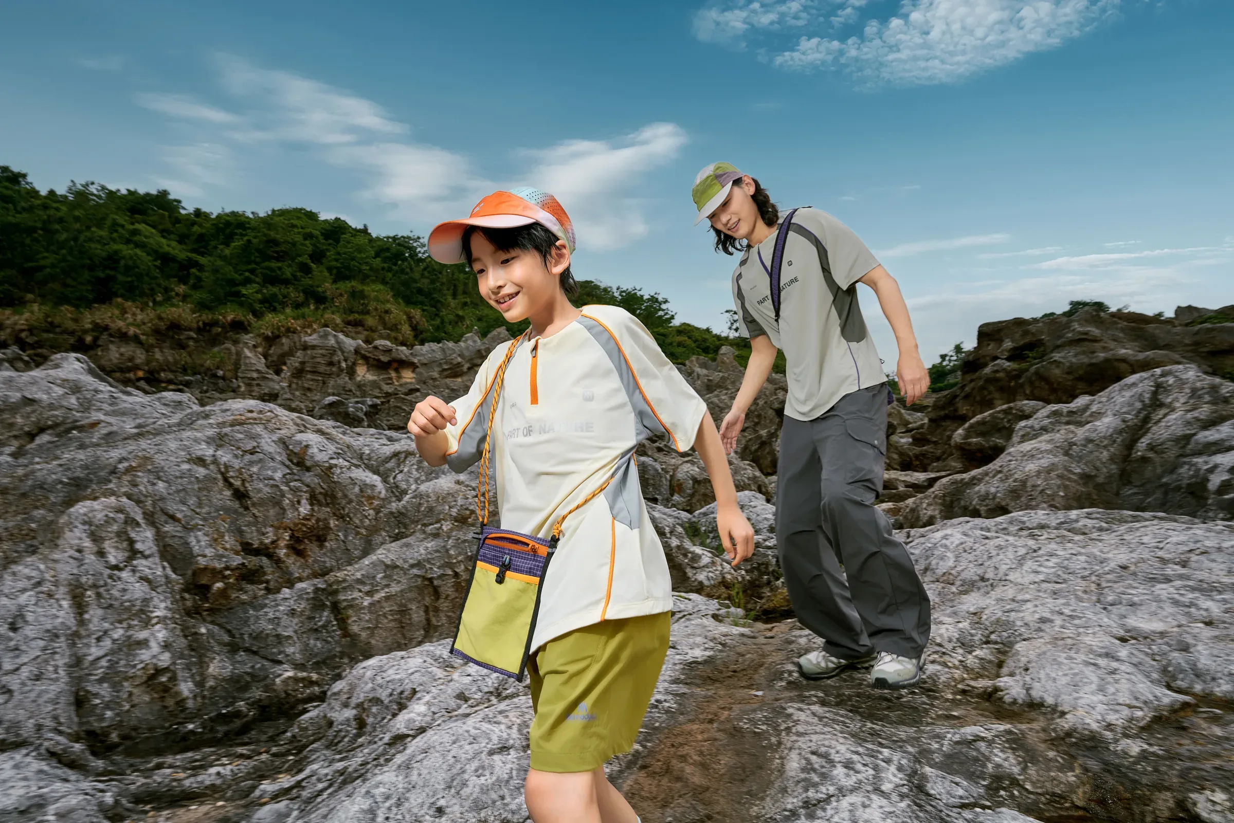 A young explorer and adult moving carefully across a rocky trail