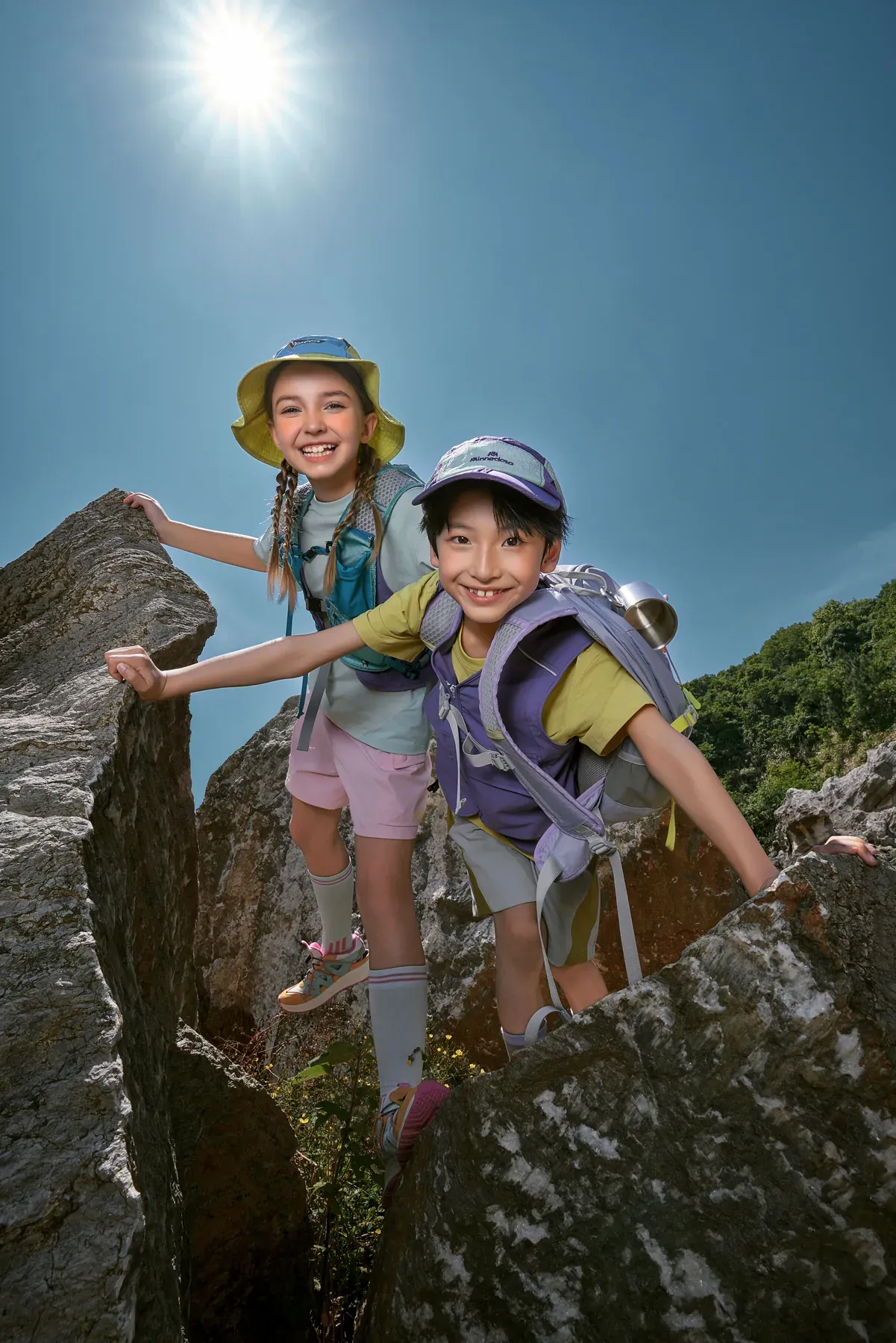 Two young explorers looking into the camera from a rocky trail