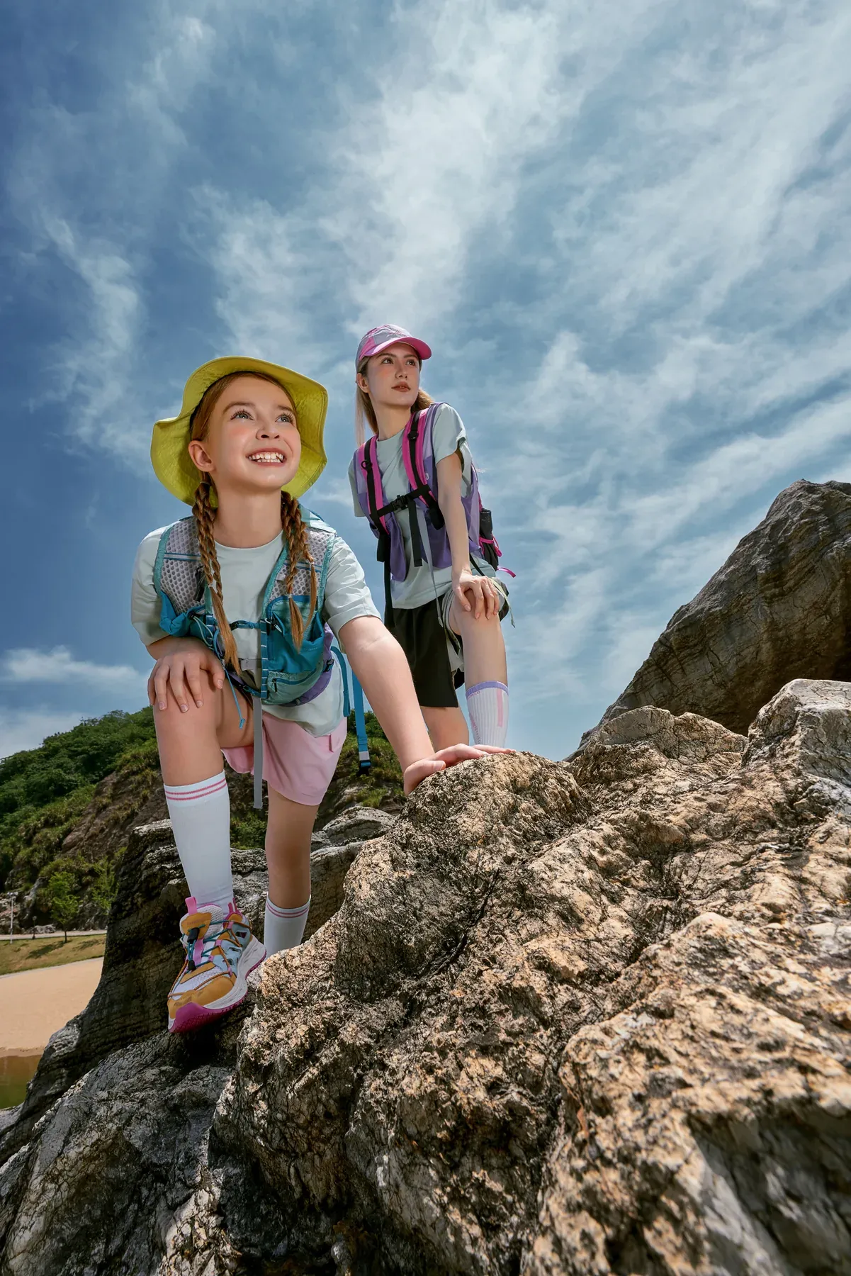 A young explorer smiling at the top of a rocky trail
