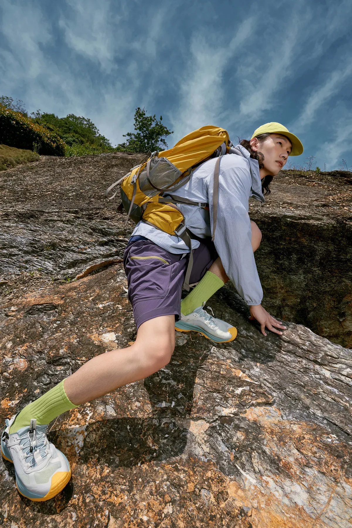 A young hiker climbing in lightweight trail clothing