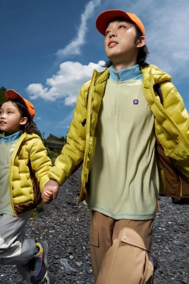 An adult and child walking together in bright insulated jackets